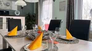 Una mesa de comedor lista con platos, vasos y servilletas.