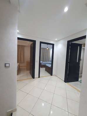 A spacious room with a tiled floor, a bed, a wardrobe, and a door leading to another room. - Superb Duplex in the center of Tangier (Tangier)