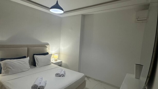 Ein Hotelzimmer mit einem Bett, einer Nachttischlampe und einem Schreibtisch mit Stuhl.