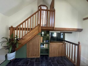 Eine Holztreppe mit eingebautem Regal und einem Blumentopf.