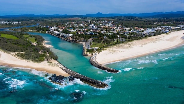 An aerial view of a coastal town with a beach, a river, and a bridge connecting the two. - Sandy Toes Paradise at Paradiso 111 (Kingscliff)