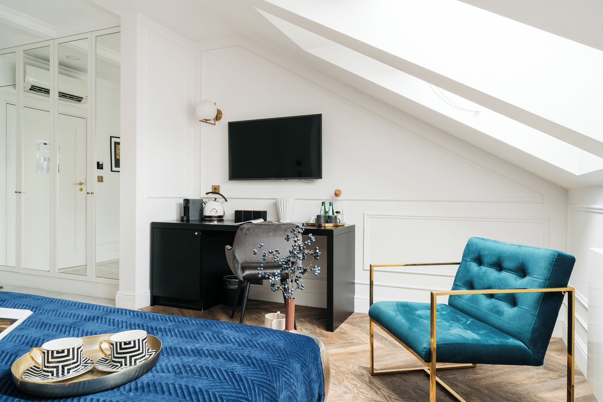 Una habitación moderna con una cama, un escritorio, una silla y un televisor.