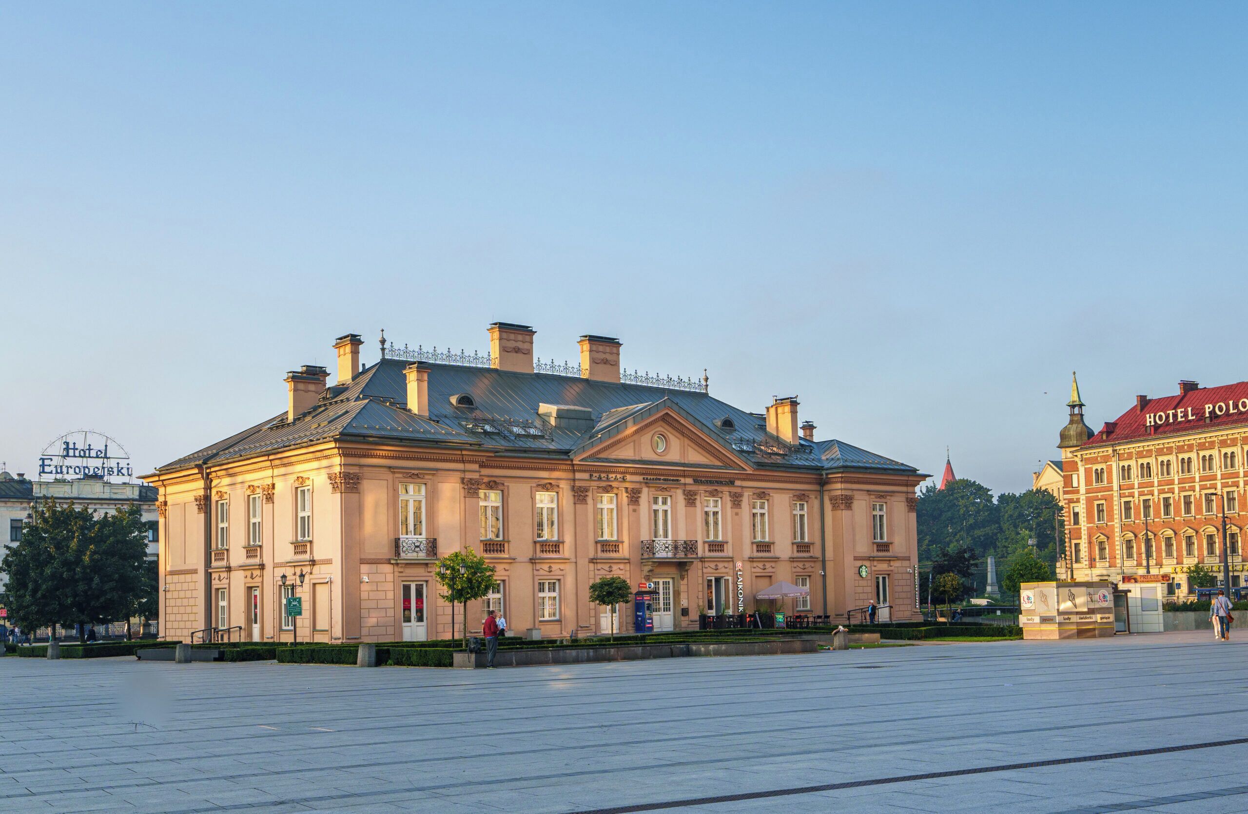 Ein historisches Gebäude mit einer symmetrischen Fassade, großen Fenstern und einem zentralen Eingang.