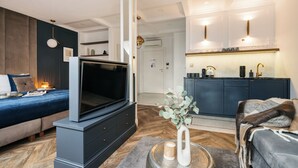 A modern living room with a flat-screen TV, a sofa, and a coffee table. - Central Palace (Kraków)
