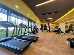 A gym with treadmills, weight machines, and a large window. - 2-bedroom apartment in lovely Alanya with AC and fitness room (Alanya)
