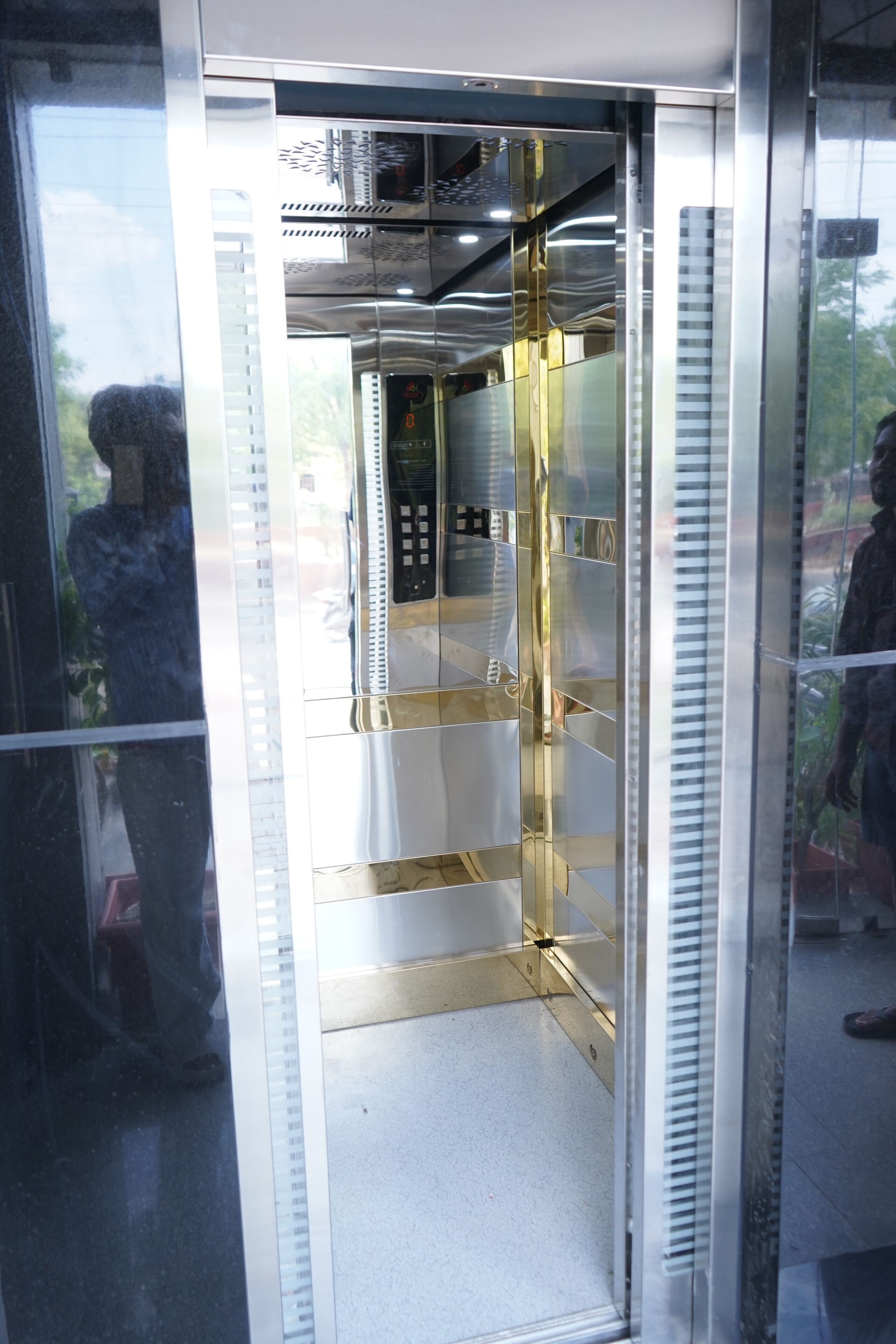 An elevator with metallic interior and reflective surfaces.
