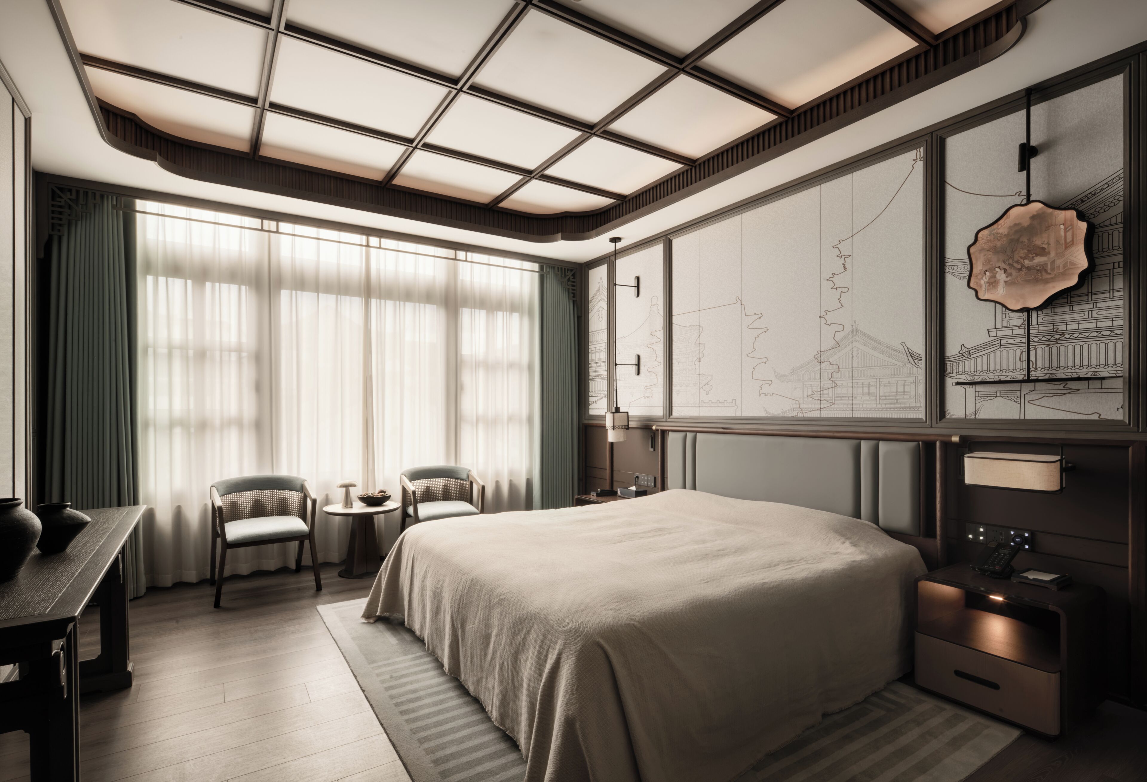A modern hotel room with a large bed, two chairs, a small table, and a large wall map.