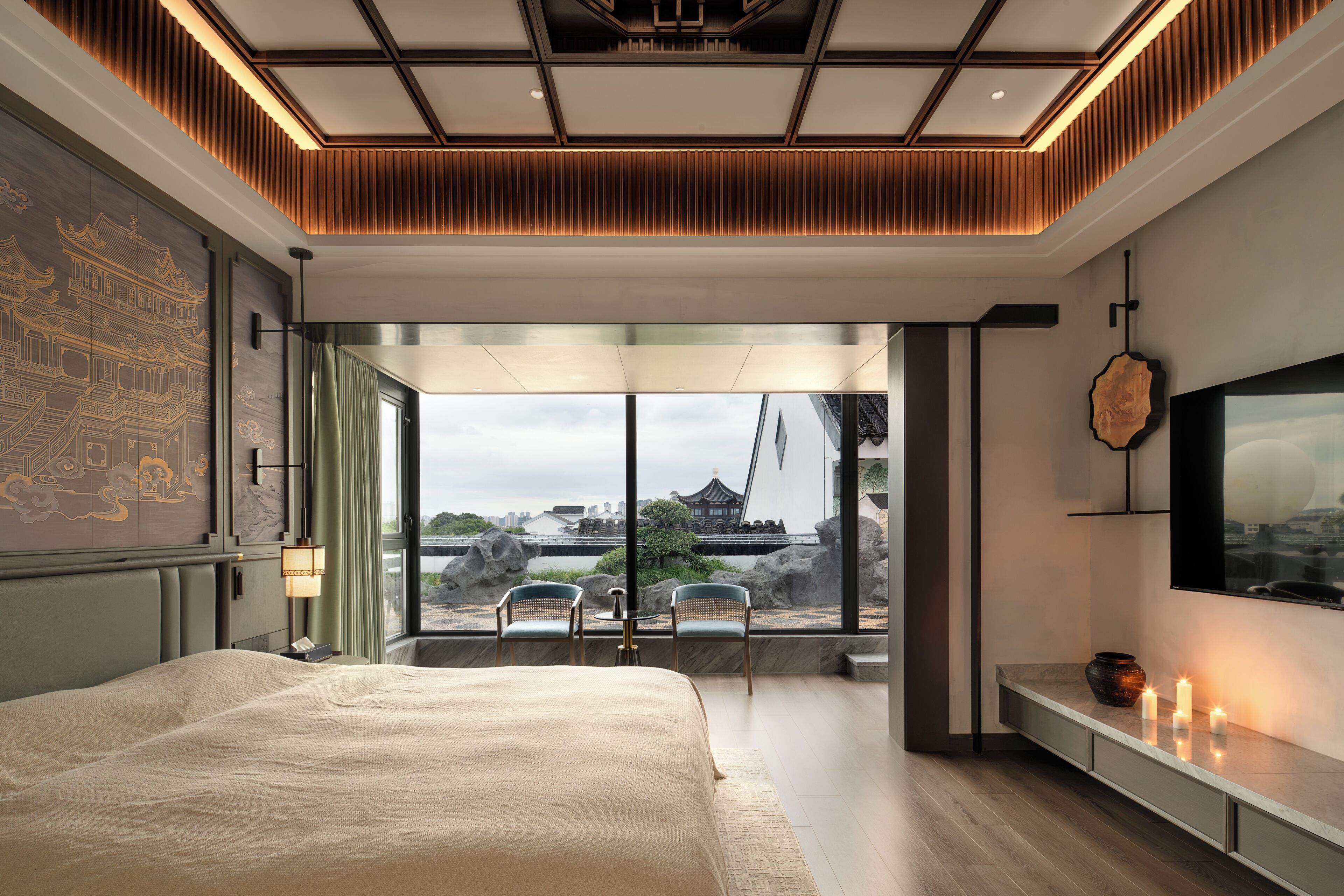 A modern bedroom with a large bed, a view of traditional architecture, and a television on the wall.