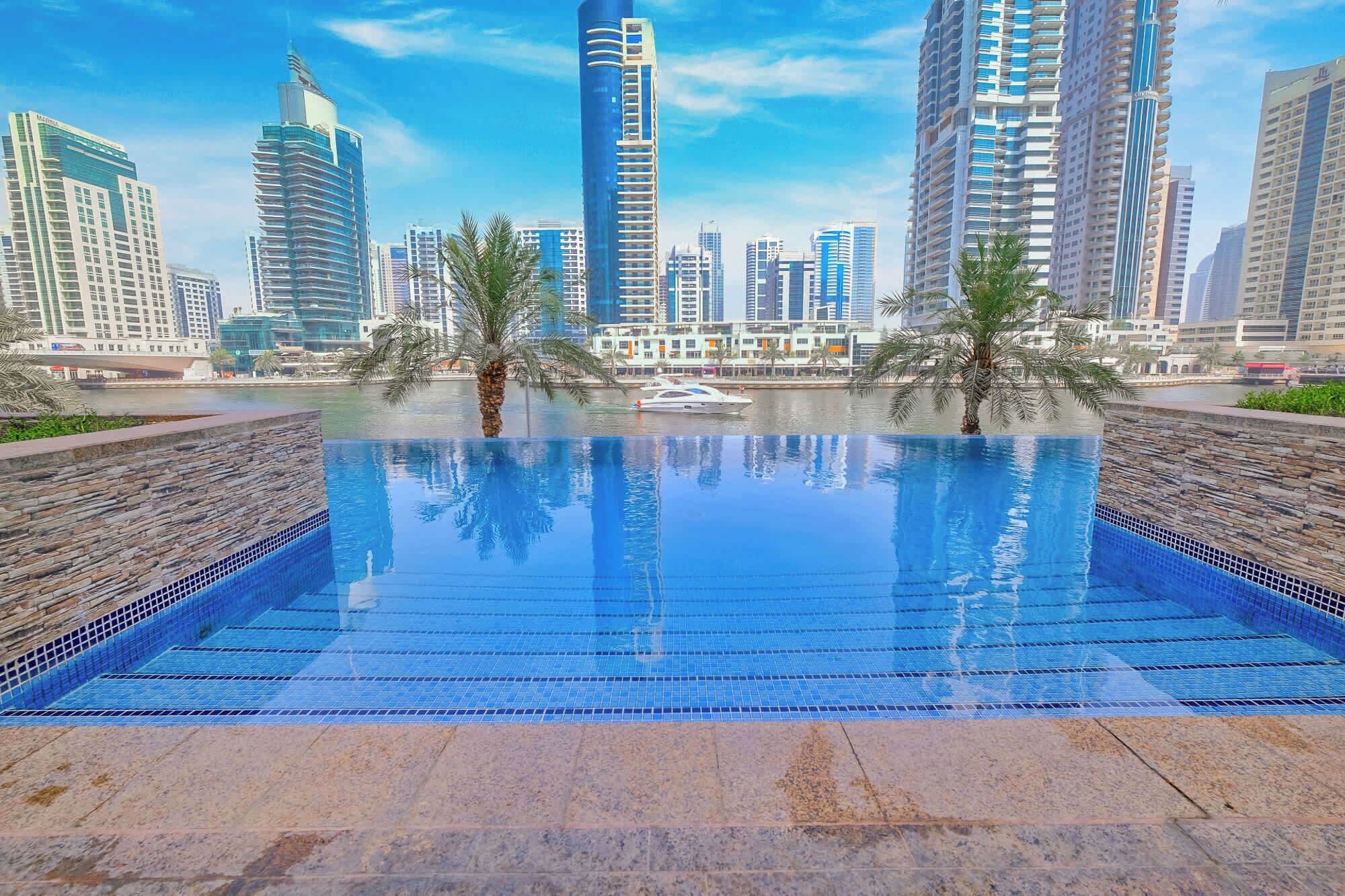 Ein Pool mit Blick auf hohe Gebäude im Hintergrund.