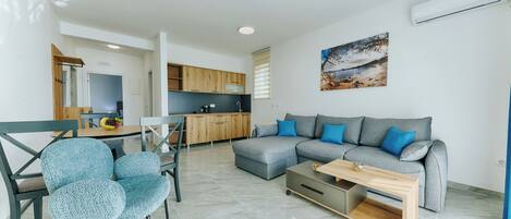 A modern living room with a grey sectional sofa, a blue armchair, and a wooden coffee table.