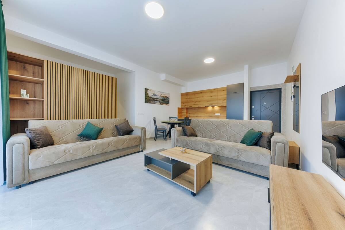 Un salon moderne avec deux canapés, une table basse et un coin repas.