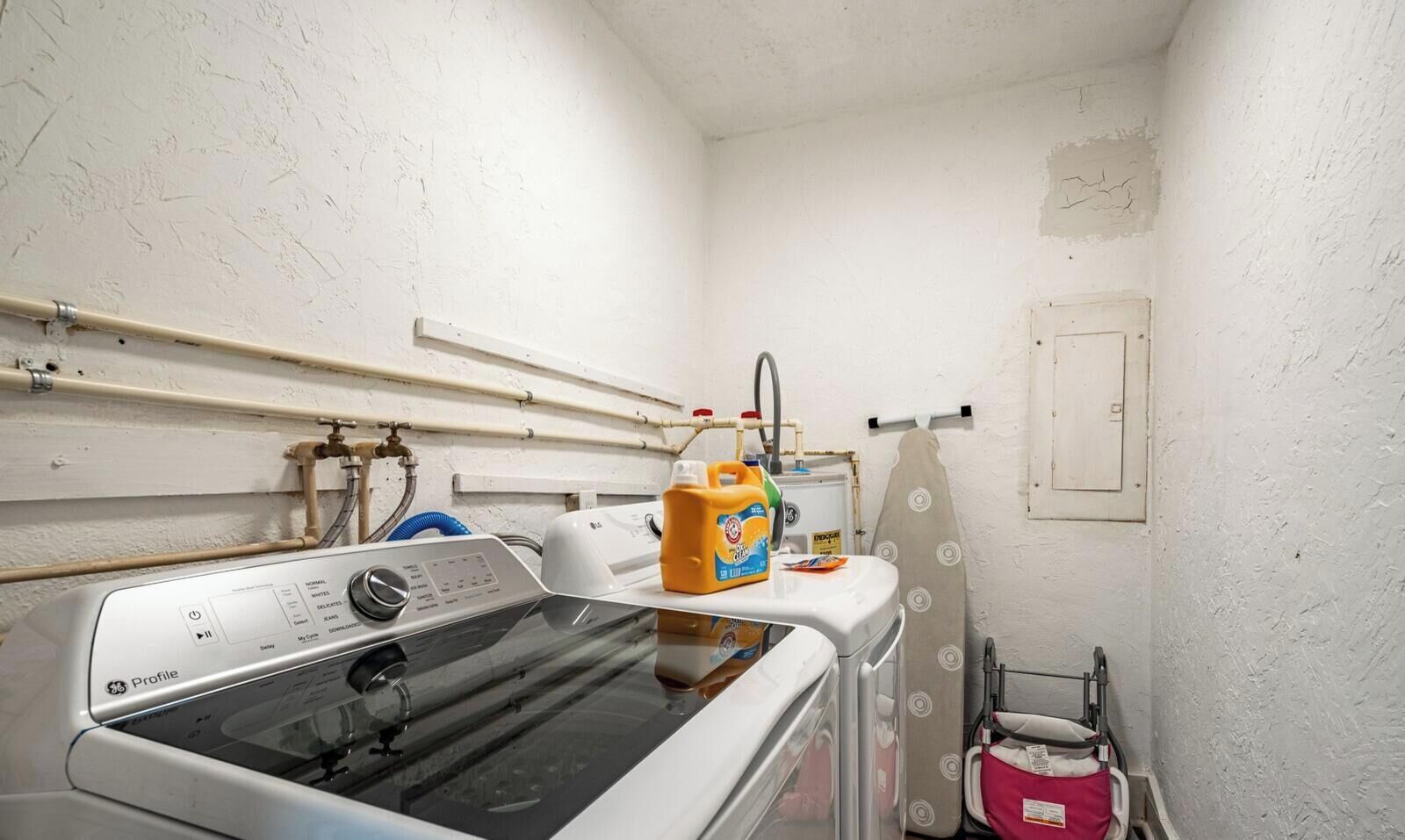 Een wasserette met een wasmachine, een droger en een boiler.