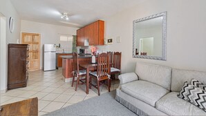 Un espacio habitable compacto con kitchenette, comedor y sofá.