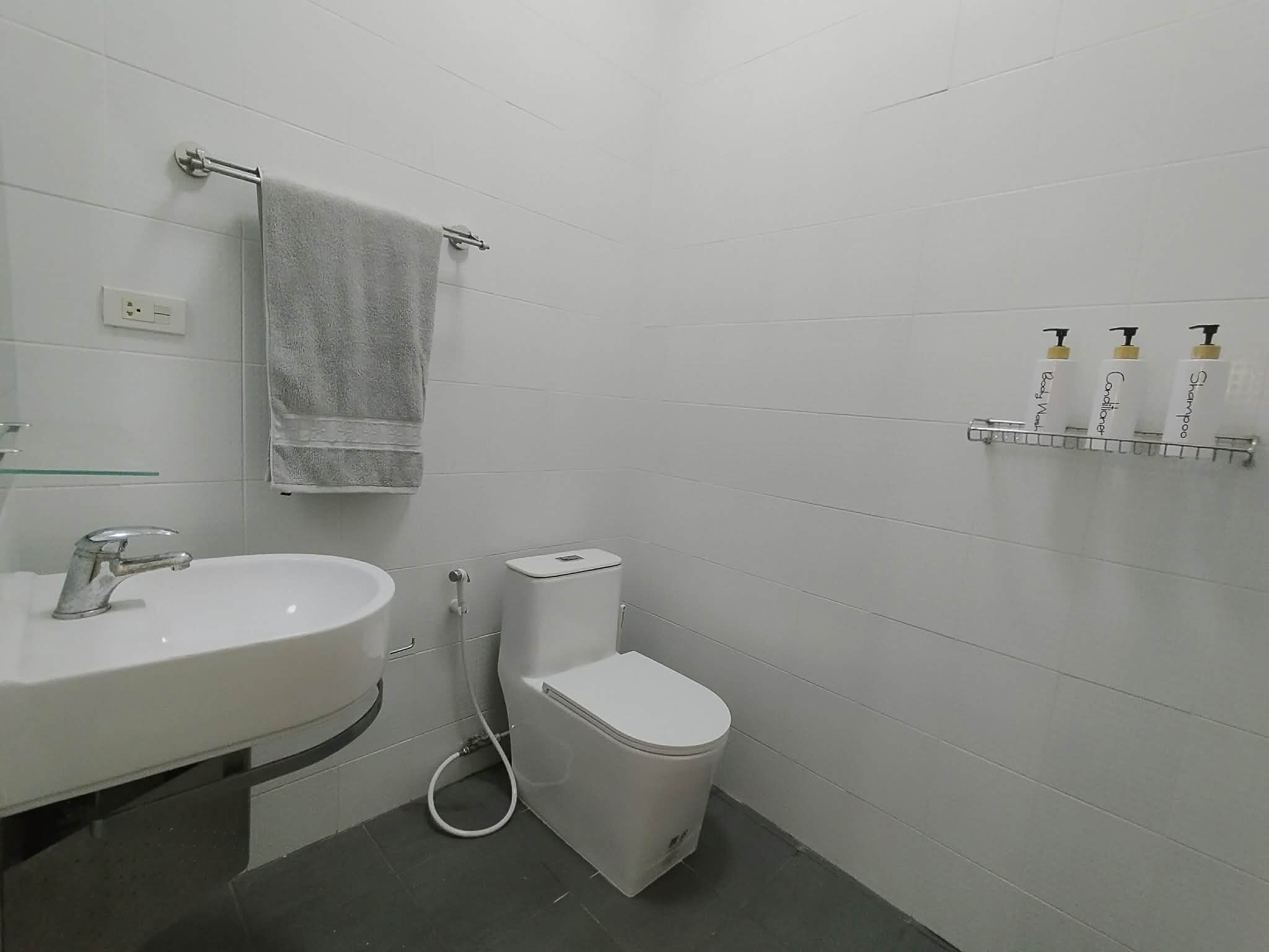 Ein Badezimmer mit Waschbecken, Toilette und Handtuchhalter.