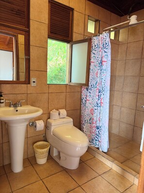 A bathroom with a sink, toilet, and shower curtain. - Tiny Cabin #4 Lake Atitlan (San Juan la laguna,)