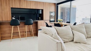 Una cucina moderna con mobili in legno, un piano di lavoro nero e un'area pranzo con tavolo e sedie.