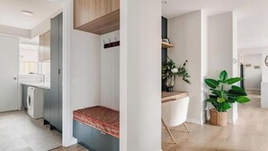 A modern interior with a built-in bench, a kitchen area, and a potted plant. - Luxury Sunbury retreat (Sunbury)