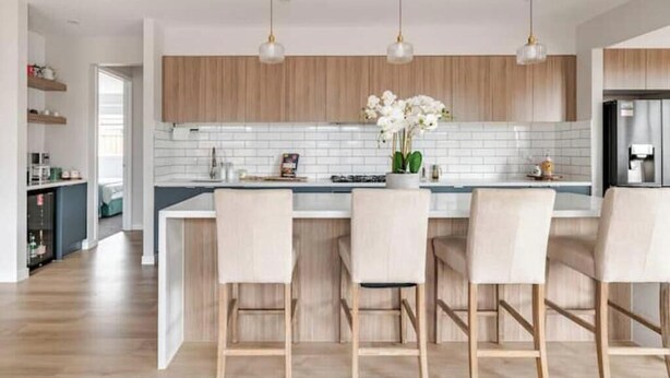 A modern kitchen with white subway tiles, wooden cabinets, and pendant lighting. - Luxury Sunbury retreat (Sunbury)