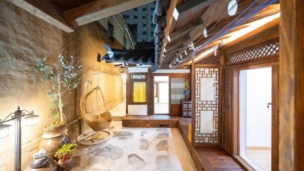 Ein traditionelles japanisches Interieur mit Tatami-Böden, Holzbalken und einer Schiebetür.