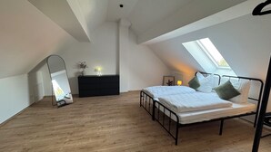 Ein Schlafzimmer mit Oberlicht, einem Bett, einem Schminktisch und einem Spiegel.