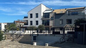 Un edificio moderno con tetto piatto, ampie finestre e facciata in pietra.