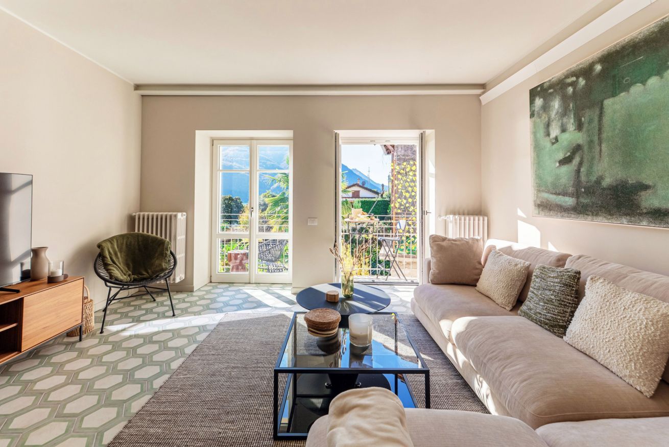 A living room with a sofa, a coffee table, a chair, a TV, and a painting on the wall.