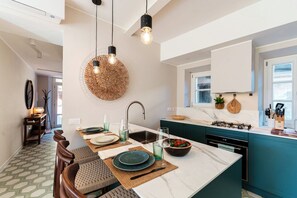 A modern kitchen with a central island, a dining area with chairs, and a hanging light fixture. - “YOU MAY FIND YOURSELF IN A BEAUTIFUL HOUSE”Immerse yourself in the magical atmosphere of this ancient village. Here, you’ll breathe in an enchanting aura filled with tranquility and romantic glimpses. Not just a home, but a gem set in a quaint set (Laglio)