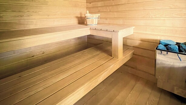 A sauna room with wooden walls and benches. - Green retreat with sauna and terrace: authentic mini apartment in Magnano (Piemonte)