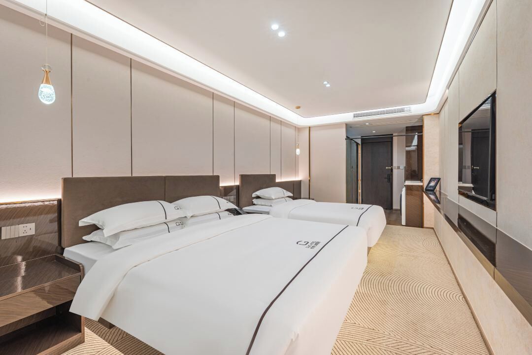 Een moderne hotelkamer met een groot bed, nachtkastjes, een televisie en een badkamer.