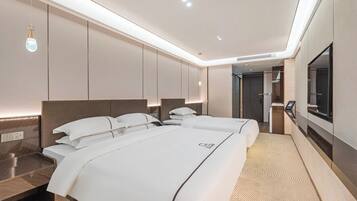 Een moderne hotelkamer met een groot bed, nachtkastjes, een televisie en een badkamer.