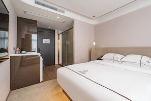 A hotel room with a bed, a desk, and a shower area. - Guike Hotel Shanghai Stadium (Shanghai)