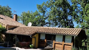 Un rustico chalet in legno con tetto a tegole, un’antenna parabolica e un piccolo portico.