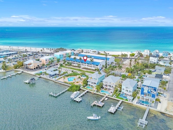 An aerial view of a coastal area with a marina, buildings, and a beach. - Summer Sands #217 2 Bedroom Home (Bradenton Beach)