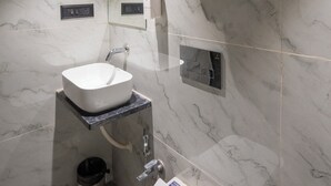 A modern bathroom with a marble wall, a sink, a mirror, and a towel rack. - Mosaic Go Star Grand (Navi Mumbai)