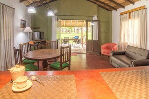 Un comedor con mesa, sillas, sofá y televisor.