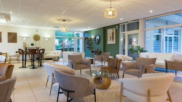 Een modern interieur met een eethoek, banken en een groot raam.