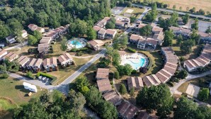 Vue aérienne d’un quartier résidentiel avec des maisons, une piscine et une route.