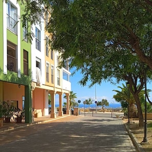 Eine Straße mit Gebäuden, Bäumen und blauem Himmel.