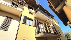 A multi-story building with balconies, a ventilation system, and a clear sky.