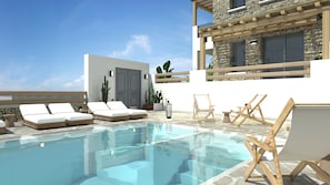 A rooftop pool with lounge chairs, a cactus, and a stone building.