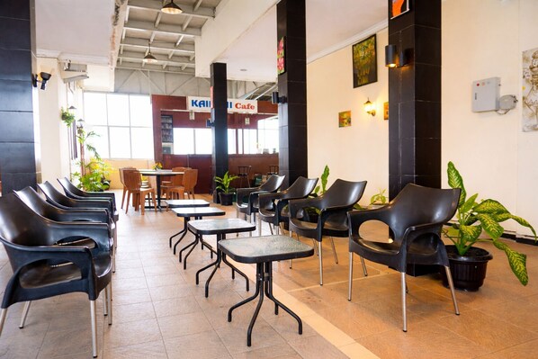 A cafe with black chairs and tables, a sign for 'Kail Cafe', and potted plants. - Siantar Hotel Parapat (Medan)
