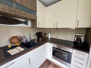 A kitchen with a stove, sink, and various appliances. - Quietly located vacation apartment (Medebach)