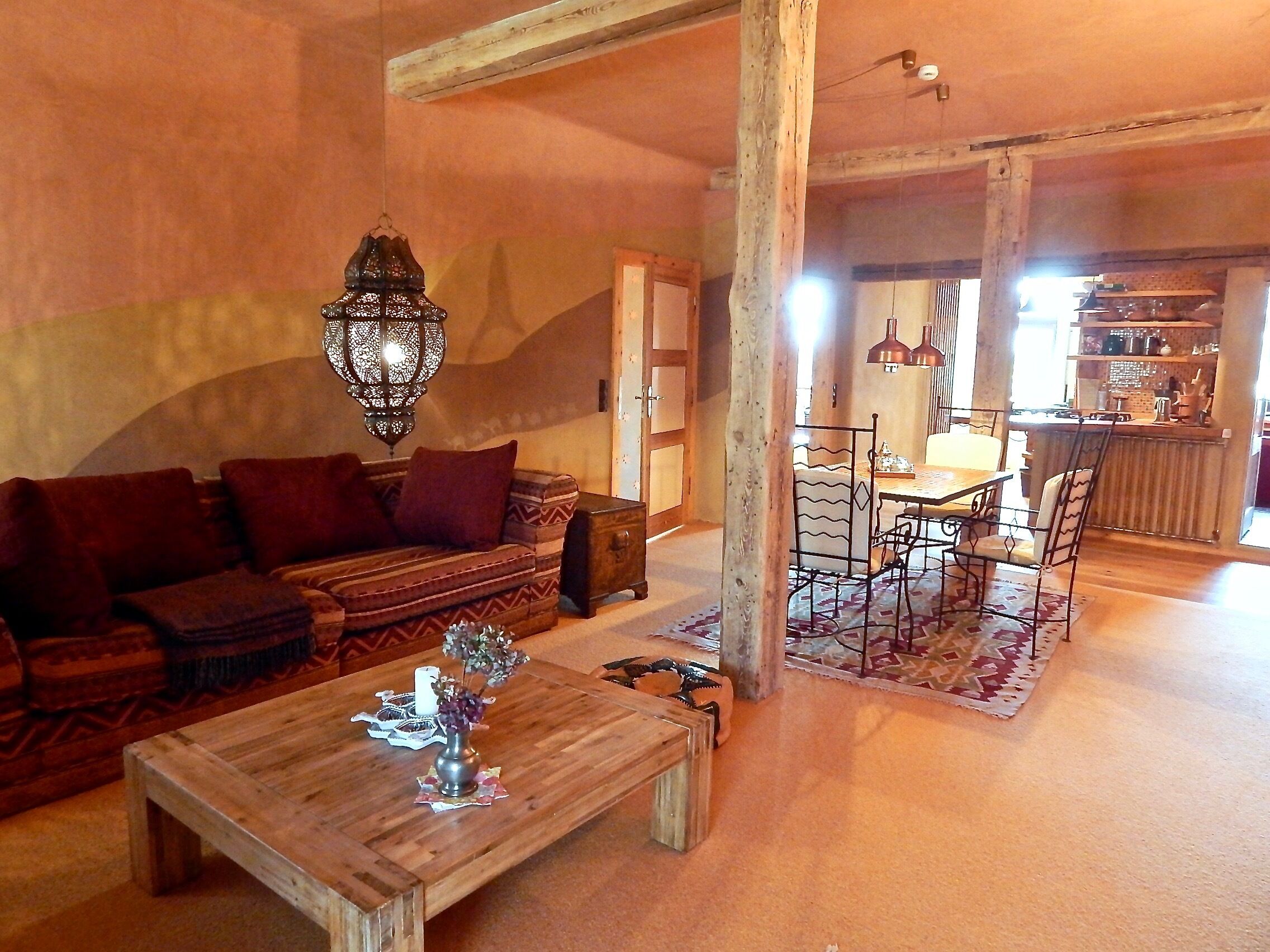 Una sala de estar acogedora con un sofá, una mesa de centro de madera y un comedor con sillas y una mesa.