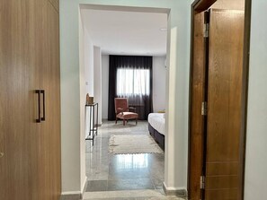 A hotel room with a bed, a chair, a desk, and a wardrobe. - Saf-saf Apartment in La Marsa (La Marsa)