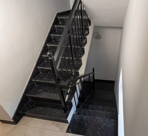 A staircase with black railings and marble steps. - 3-bedroom Premium Serviced Apt right in front of Vaigai River, Kochadai, Madurai (Madurai)