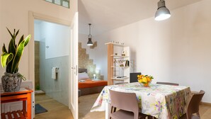 A room with a bed, a table with chairs, a bookshelf, and a potted plant. - Apartment 'U Curtigliu -' with Shared Terrace, Wi-Fi and Air Conditioning (Realmonte)
