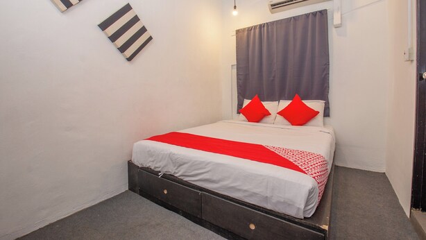 Une chambre à coucher avec un lit, un climatiseur fixé au mur et une porte.