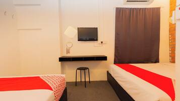 Quarto de hotel com duas camas, televisão, escrivaninha e ar condicionado.