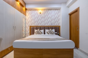 Een slaapkamer met een bed, een houten garderobe en een wandlamp.