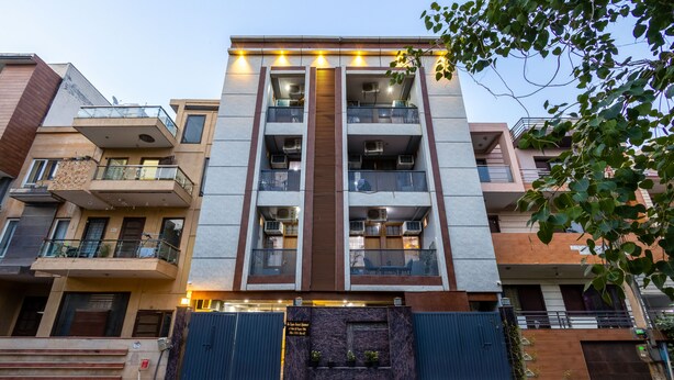A multi-story building with balconies, a central entrance, and a gated driveway. - The Empire Sector 45 Gurgaon (Gurugram)